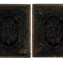 Back of open black photograph frame. Made of embossed decorative leather.