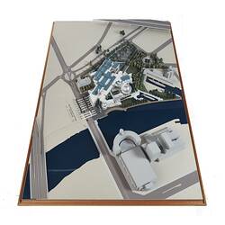 Cardboard model of building with two silver domes. Beside it is a river with a bridge.