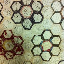 Hexagons of coloured fabric stitched together.