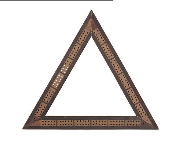Front of hollow triangular wooden cribbage board. Has holes punched throughout.