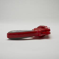 Red and grey plastic toy revolver, back view.