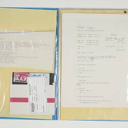 Open blue folder. White pages on left and right have printed and handwritten text. Floppy disk on left.