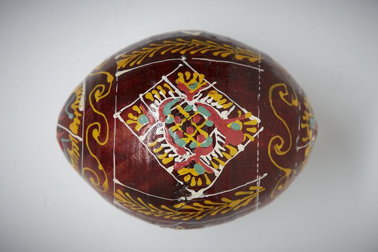 Egg, hand painted brown background with yellow, white and green diamond design.