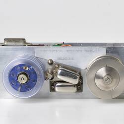 Small metal box two wired reels on top. One reel is blue plastic the other metal.