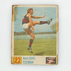 Football card, number 22, with player kicking ball, leg up and extended.