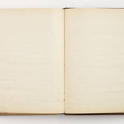 Open book with off white ruled pages.