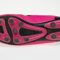 Pink Australian Rules football boot with black bootlace, lining and sole.