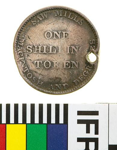 Round coin with raised text. Hole punched on right side near edge.