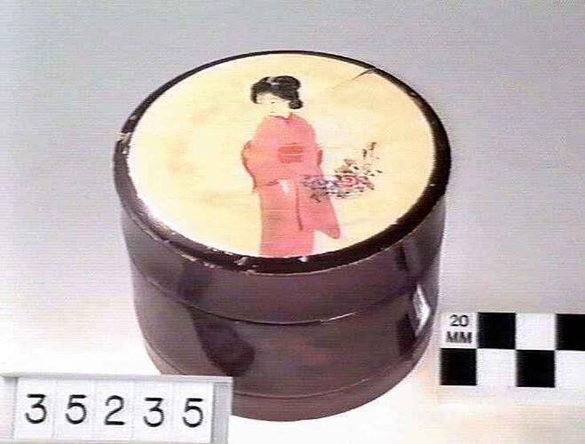 Round lidded box with image of woman on lid.