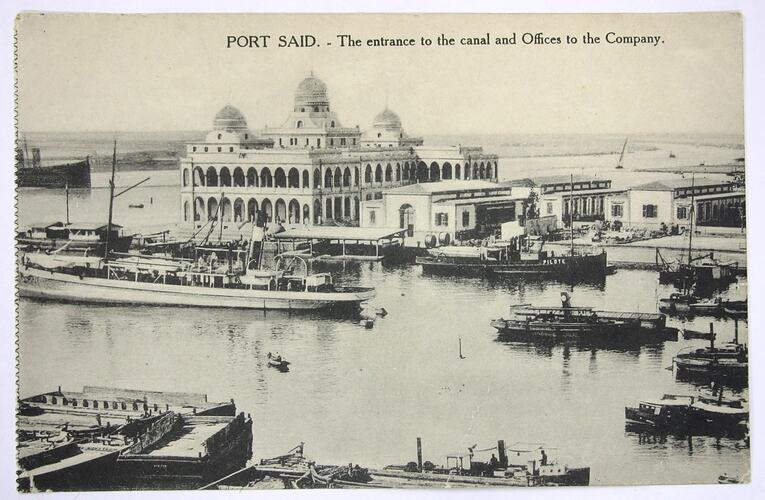 Boats in harbour edged by buildings.