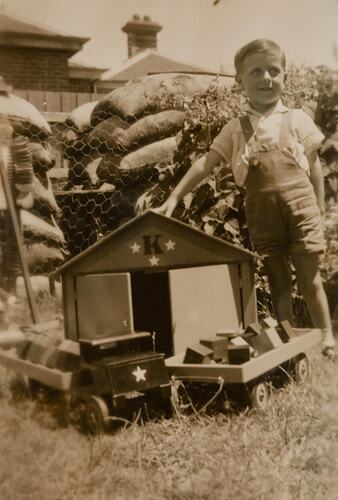 Digital Photograph - Boy with Wooden Toys in front of Air Raid Shelter, Prahran, Christmas 1942
