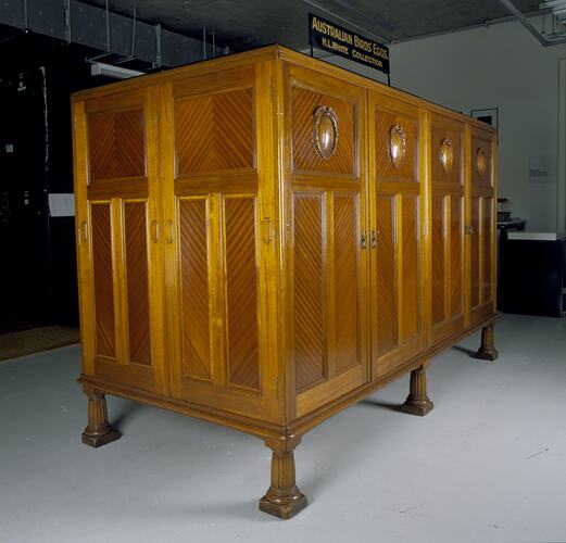 Wooden cabinet in collection store with a sign above it.