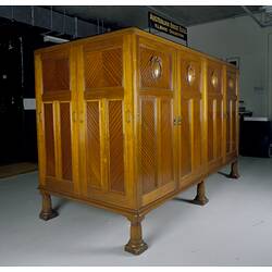 Wooden cabinet in collection store with a sign above it.