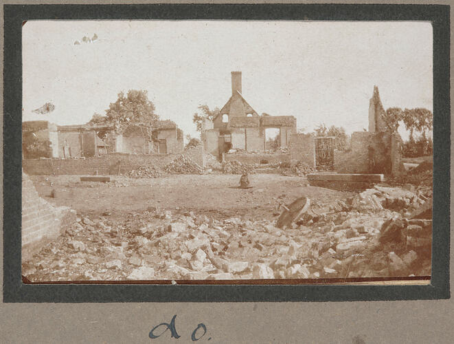 Bomb damaged buildings and debris, with piles of debris in the foreground.