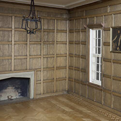 Small room with wooden walls and fireplace.