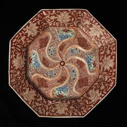 Octagonal Imari porcelain plate with ochre-coloured oriental flower design.