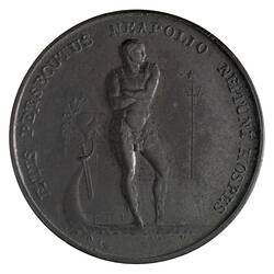 Round medal with male statue. Text around.