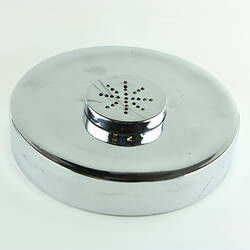 Round shiny metal container. Lid has round central vent.