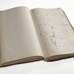 Open book. The left page is blank, the right side has handwritten cursive text in ink.