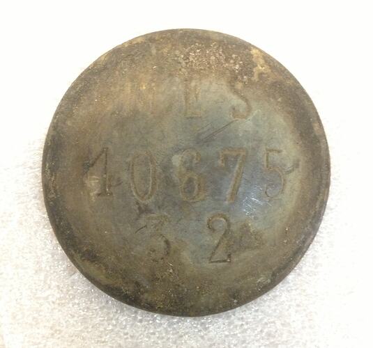 Round metal tag with inscription.