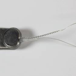 Bionic ear prototype. Round disc with two wires at end.