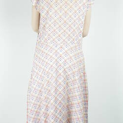 Knee length sleeveless dress with white, yellow, blue and red checked pattern, back view.