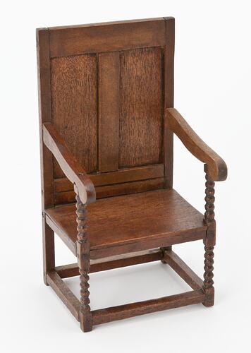 Wooden chair with two arms and turned legs.