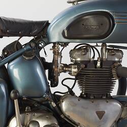 Blue metallic motor cycle. Seat, tank and engine detail, right profile.