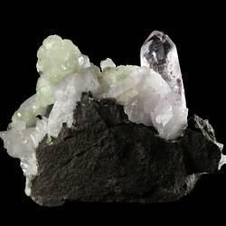 Tall purple crystal with smaller blocky green crystals.