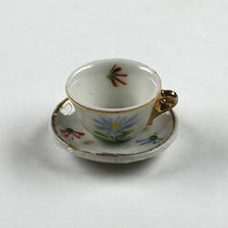 Side view of tiny tea cup and saucer.