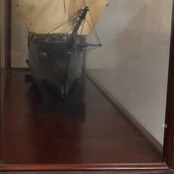 Sailing ship model in glass case, front view.