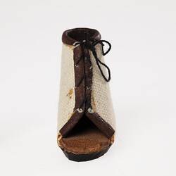 Miniature white canvas prosthetic open toe lace-up shoe. Black rubber sole.
