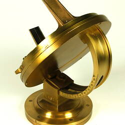 Three quarter view of gold metal chronometer.