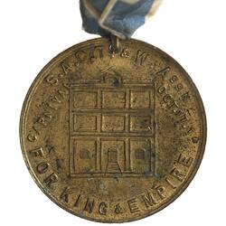 Medal with three boxes high and across building, text around.