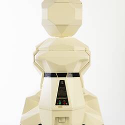Back view of cream plastic robot with angular human-like shape, ie. head, shoulders, waist and legs. Black plastic features.