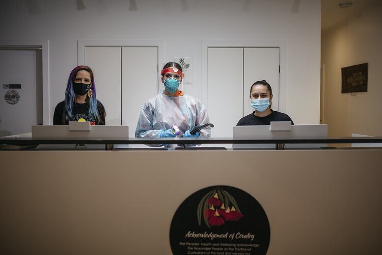 Staff Members Stand Behind Reception at First Peoples Health and Wellbeing Clinic, Thomastown, Wurundjeri Woi Wurrung Country, Victoria, 25 Mar 2021