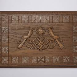 Rectangular wooden album cover intricately carved with two central birds framed by square patterned border.