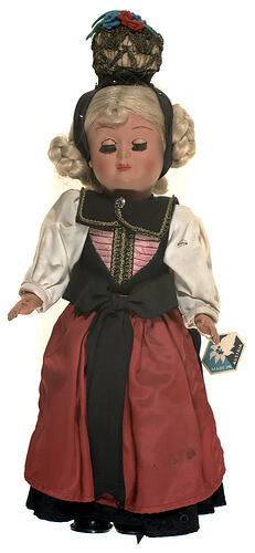 Blonde doll in Austrian national costume of red, cream and black.