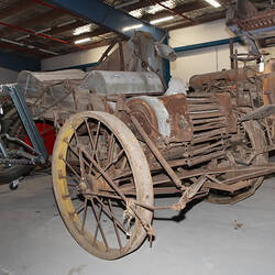Weathered, worn self-propelled harvester with standard front, pick-up front, rice front and pea front.