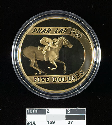 Bronze coin, plastic case, picture of race horse.