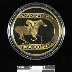 Bronze coin, plastic case, picture of race horse.