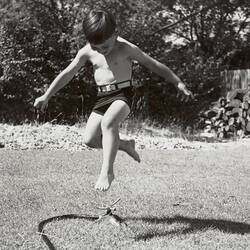 Digital Photograph - Boy Jumping Over Rotating Sprinkler, Backyard, Blackburn, 1953