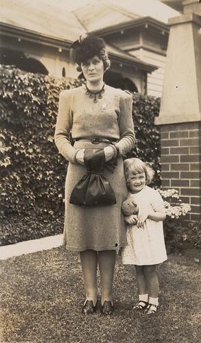 Digital Photograph - Woman wearing World War 2 'Female Relatives' Badge and Daughter, Front Garden, Brunswick West, 1943