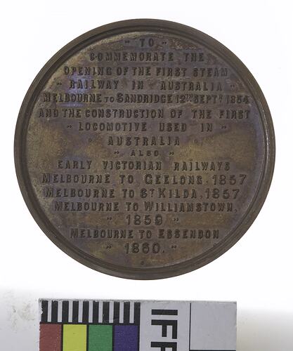 Round medal with lettering in relief.