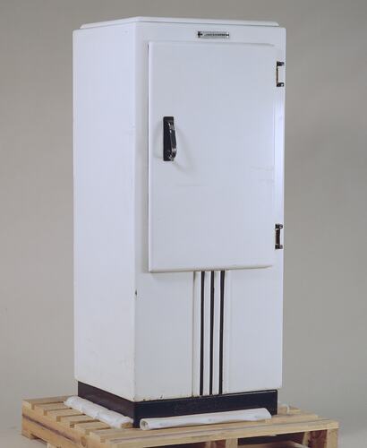 White rectangular refrigerator with black handle. Three black vertical stripes on lower section.