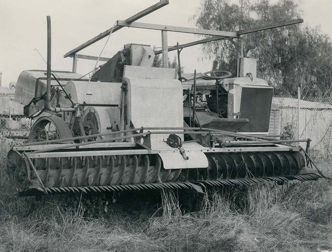 Front view of Auto Header harvester in yard.