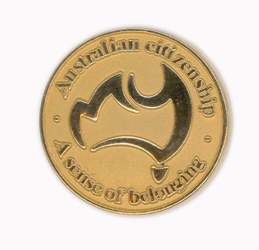 Round gold badge with stylised Australia map in centre. Text around edge.