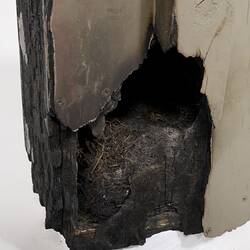 Detail of corner of fire damaged off-white painted wooden box.