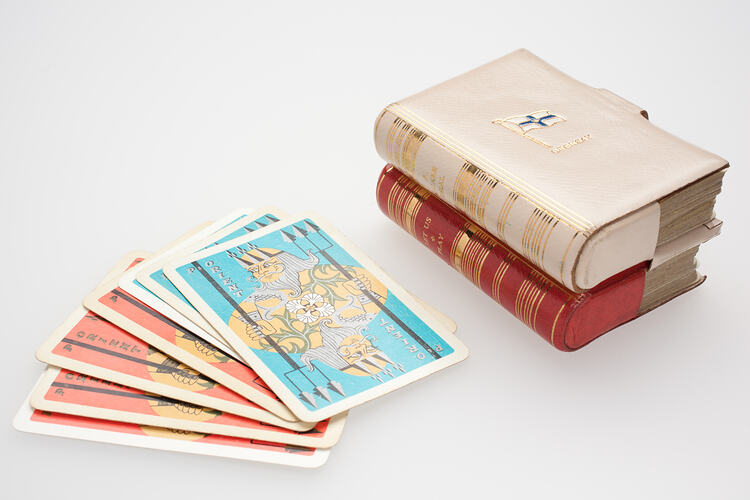 Old fashioned playing cards and cases shaped as books.