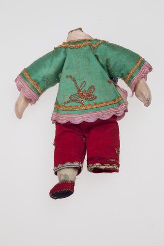 Headless doll dressed in green and red Chinese costume.